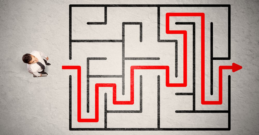 Lost businessman found the way in maze with red arrow on grungy background